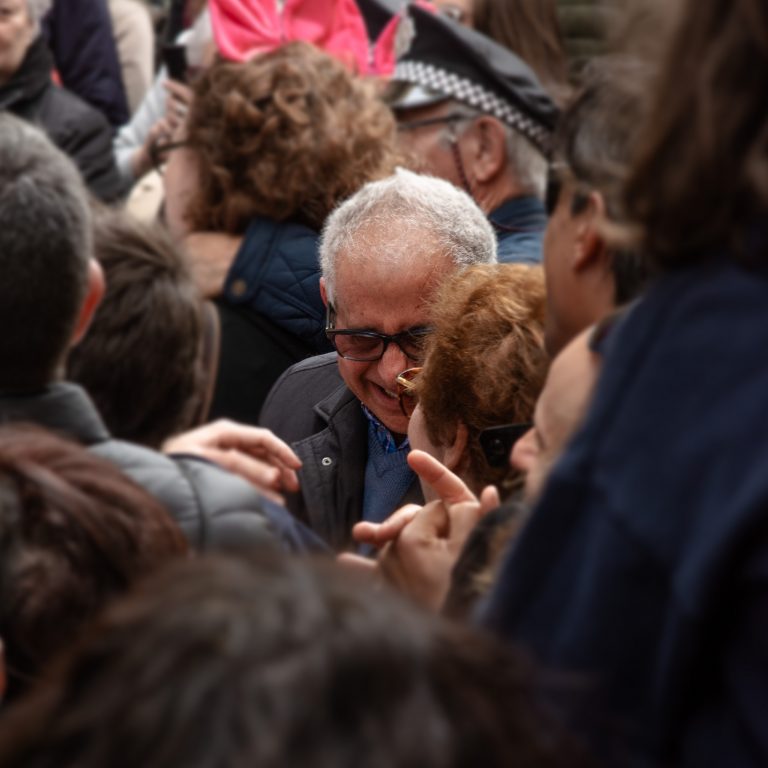 Hombre anciano riéndose con su compañera entre el público de un corro de carnaval. Cádiz 2023