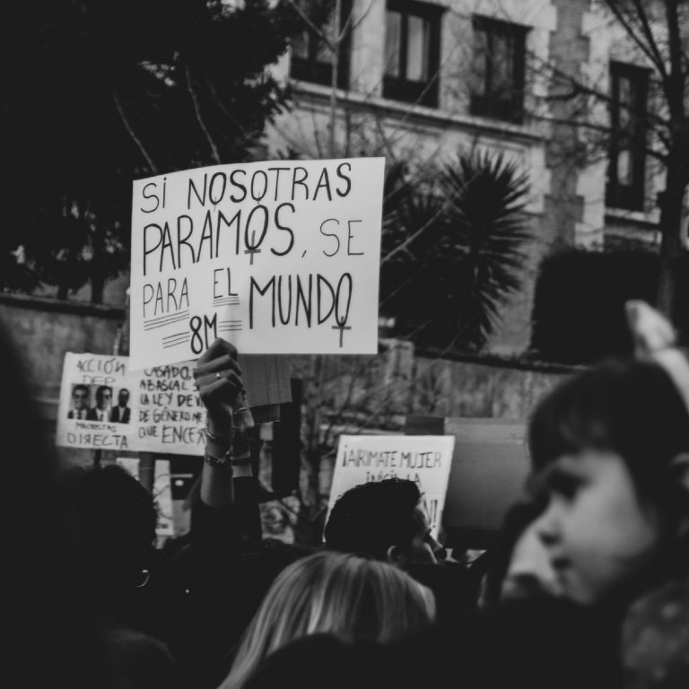 Brazo en alto sujetando una pancarta con cánticos feministas en una manifestación del 8M
